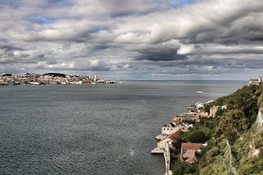 Panoramic of the docks of Cacilhas village and Tagus river on a cloudy day