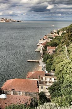 Panoramic of the docks of Cacilhas village and Tagus river on a cloudy day