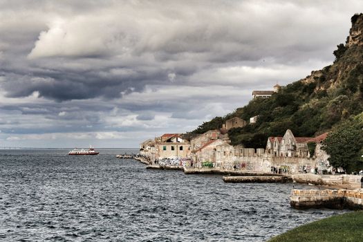 Panoramic of the docks of Cacilhas village and Tagus river on a cloudy day