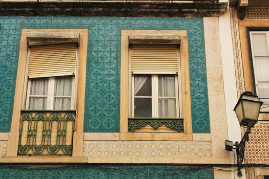 Old and colorful facade in Lisbon with plants and vintage lantern