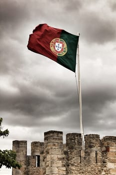 Portugal flag waving under cloudy sky in Saint George Castle in Lisbon