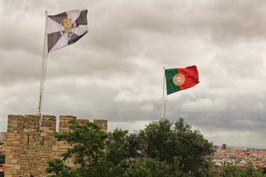 Portugal flag waving under cloudy sky in Saint George Castle in Lisbon