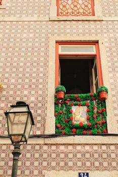 Old and colorful facade in Lisbon with plants and vintage lantern