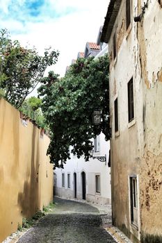 Old colorful houses and narrow streets of Lisbon, Portugal in Spring. Majestic facades and old street lights.