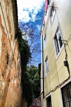 Old colorful houses and narrow streets of Lisbon, Portugal in Spring. Majestic facades and old street lights.