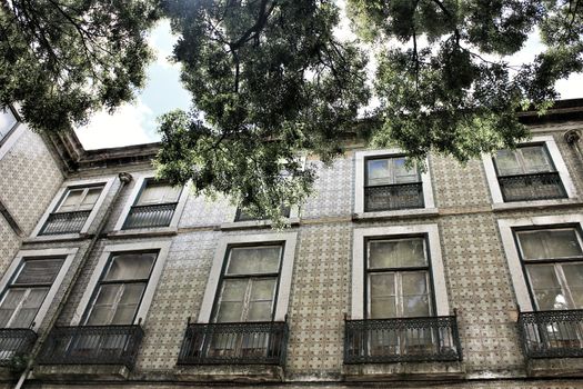 Old colorful and majestic tiled facades with vintage streetlight in Lisbon streets in Spring.