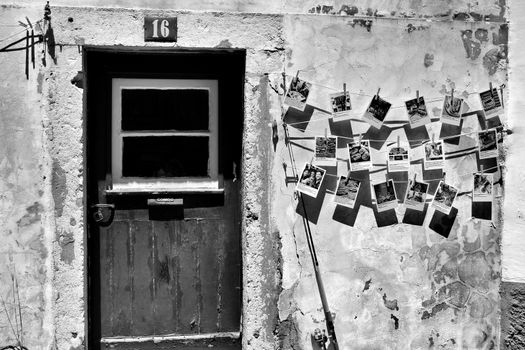 Old wooden door with stone facade and postal cards hanging on the wall.