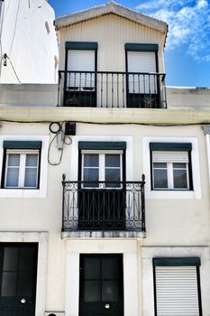 Old and colorful facade in Lisbon with plants and vintage lantern