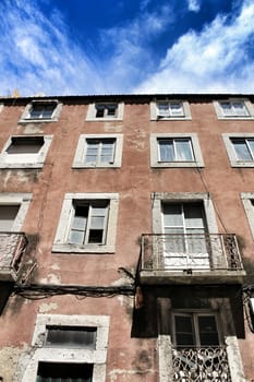 Lisbon, Portugal- June 3, 2018: Old colorful houses and narrow streets of Lisbon, Portugal in Spring. Majestic facades and old street lights.