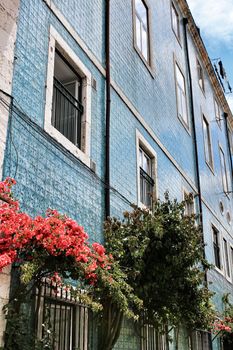 Old colorful and majestic tiled facades with vintage streetlight in Lisbon streets in Spring.