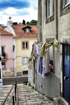 Old facade of typical Lisbon house with hanging clothes in clothesline.