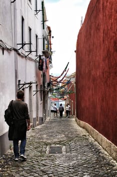 Lisbon, Portugal- June 10, 2018: Old colorful houses and narrow streets of Lisbon, Portugal in Spring. Majestic facades and old street lights.