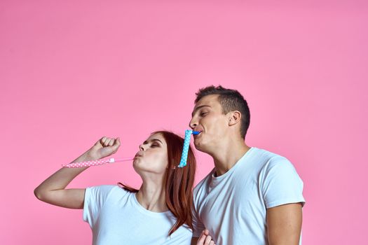 enamored man and woman hugging each other on a pink background cropped with Copy Space family portrait. High quality photo