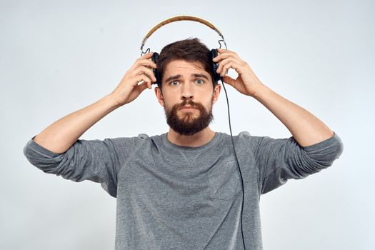 Man in headphones listens to music lifestyle modern style technology light background. High quality photo