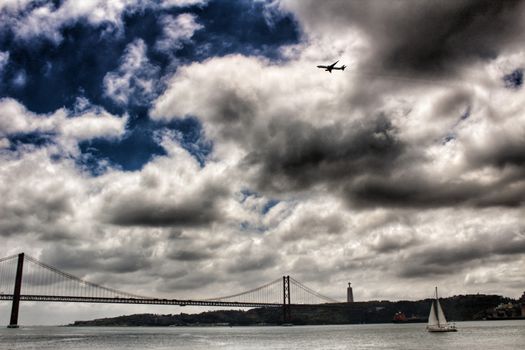 Banks of the river Tagus in Lisbon in Spring on a cloudy day. Beautiful 25th April bridge structure.