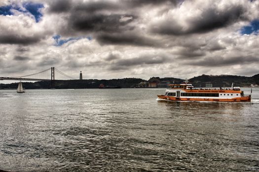 Lisbon, Portugal- June 3, 2018: Passengers boat Sailing along the Tagus river in Lisbon in the afternoon on a cloudy day.