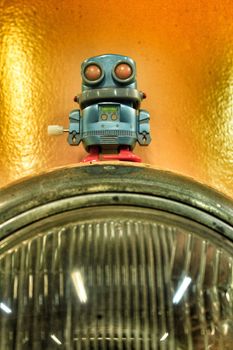 Toy robot on front yellow vintage light of car