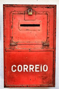 Colorful metallic mail box in red color on wall with old paint in Lisbon. Mail word written.