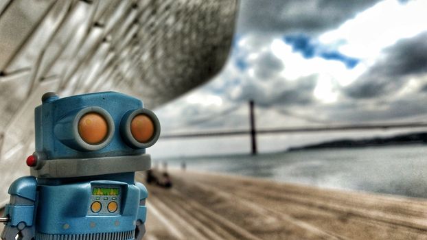 Toy robot on the banks of the Tagus River in Lisbon in a Cloudy day