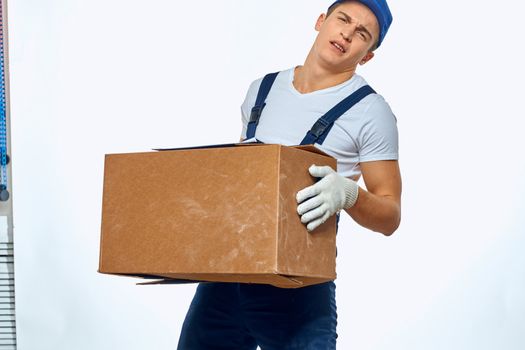 Man worker with box in hands delivery loading service work light background. High quality photo