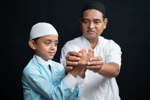 Muslim Father teaching his son how to do Salah or payer in a Islamic way