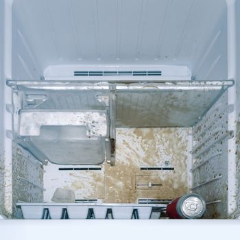 dirty freezer of modern frigerator with splash of carbonated drink