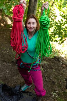 Attractive woman holding colorful rock climbing ropes
