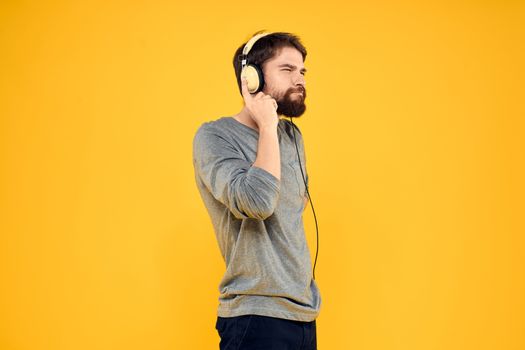 Man with headphones music lifestyle lifestyle technology yellow background. High quality photo