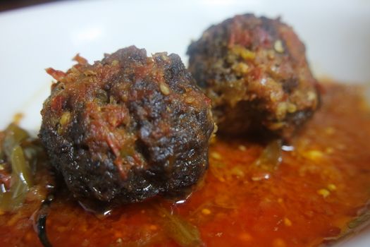 Closeup view with selective focus of meatball dish.Top view of meat balls or meat kofta curry in masala gravy in a ceramic plate.