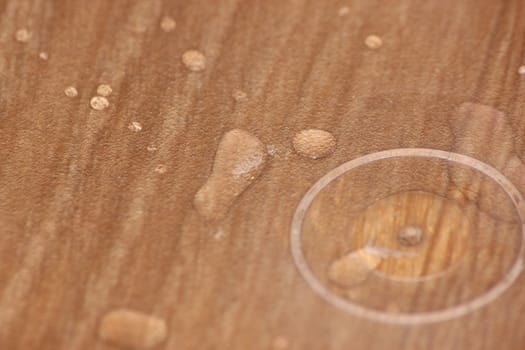 Closeup selective focus view of water drops on wooden floor. Abstract raindrops pattern on wooden board