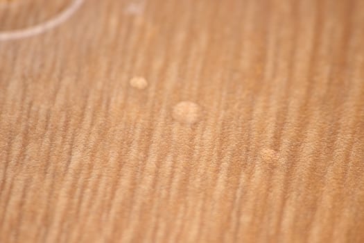 Closeup selective focus view of water drops on wooden floor. Abstract raindrops pattern on wooden board