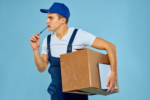 Man worker with cardboard box delivery loader lifestyle blue background. High quality photo