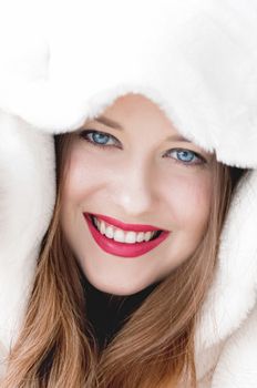 Young woman in fluffy fur coat with hood wrap, warm winter clothing for fashion and Christmas holidays design