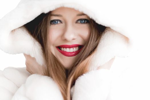 Young woman in fluffy fur coat with hood wrap, warm winter clothing for fashion and Christmas holidays design