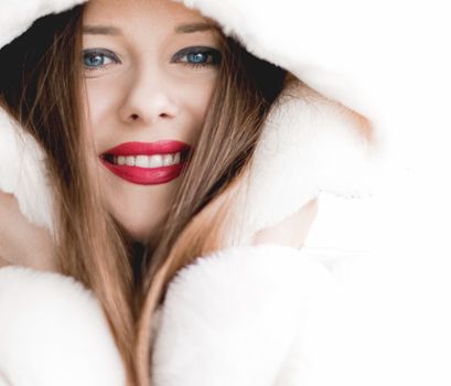 Young woman in fluffy fur coat with hood wrap, warm winter clothing for fashion and Christmas holidays design