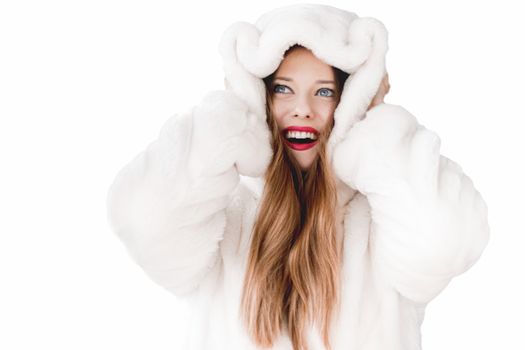 Young woman in fluffy fur coat with hood wrap, warm winter clothing for fashion and Christmas holidays design