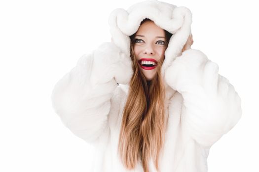 Young woman in fluffy fur coat with hood wrap, warm winter clothing for fashion and Christmas holidays design