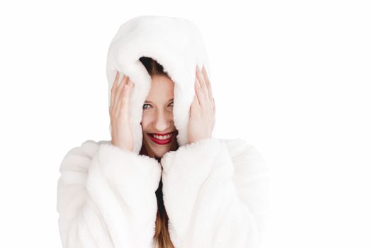 Young woman in fluffy fur coat with hood wrap, warm winter clothing for fashion and Christmas holidays design