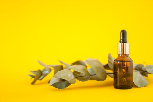 Cosmetic bottles with serum on a bright yellow background. Cosmetology and beauty concept.