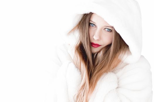 Young woman in fluffy fur coat with hood wrap, warm winter clothing for fashion and Christmas holidays design