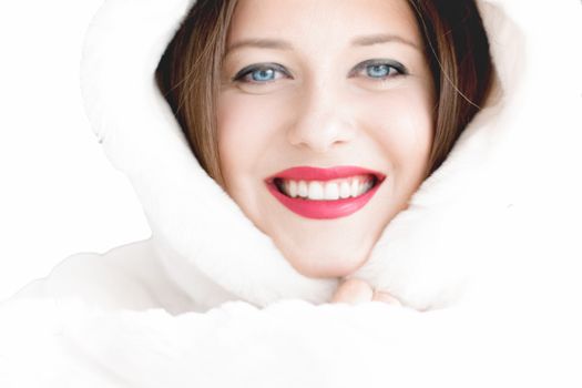 Young woman in fluffy fur coat with hood wrap, warm winter clothing for fashion and Christmas holidays design