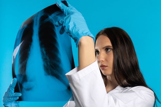 A young lady doctor in the office looks at the lungs and expects a good result.