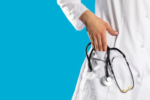 Close-up view of a hospital apron with a stethoscope in his hand.