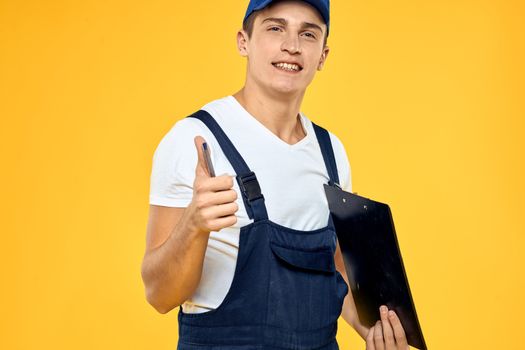Man in working uniform documents rendering of services delivery service yellow background. High quality photo