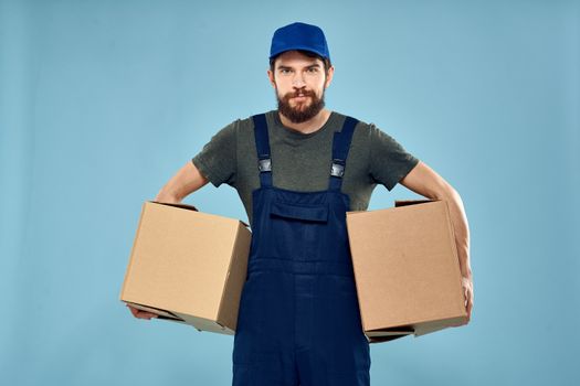 working man boxes in hands delivery service packaging lifestyle blue background. High quality photo