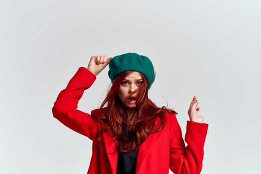 Woman in red coat and in green hat on isolated background cropped model with Copy Space emotions. High quality photo