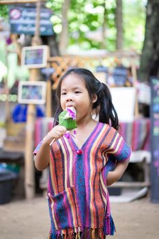 Asian little girl eating an ice cream in the market