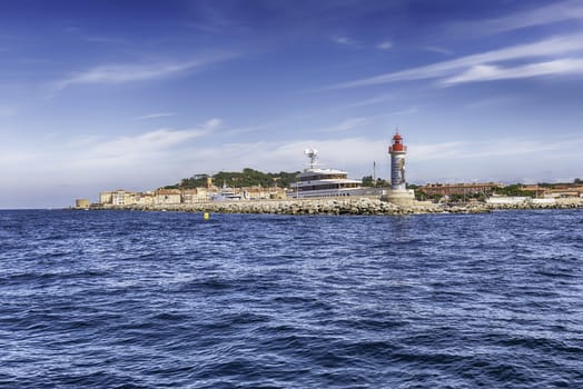 The iconic lighthouse in the harbor of Saint-Tropez, Cote d'Azur, France. The town is a worldwide famous resort for the European and American jet set and tourists