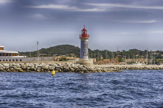 The iconic lighthouse in the harbor of Saint-Tropez, Cote d'Azur, France. The town is a worldwide famous resort for the European and American jet set and tourists