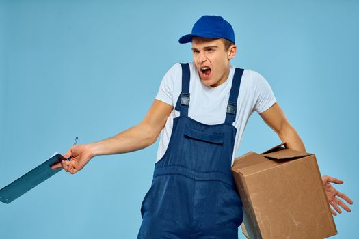 Man worker with cardboard box delivery loader lifestyle blue background. High quality photo